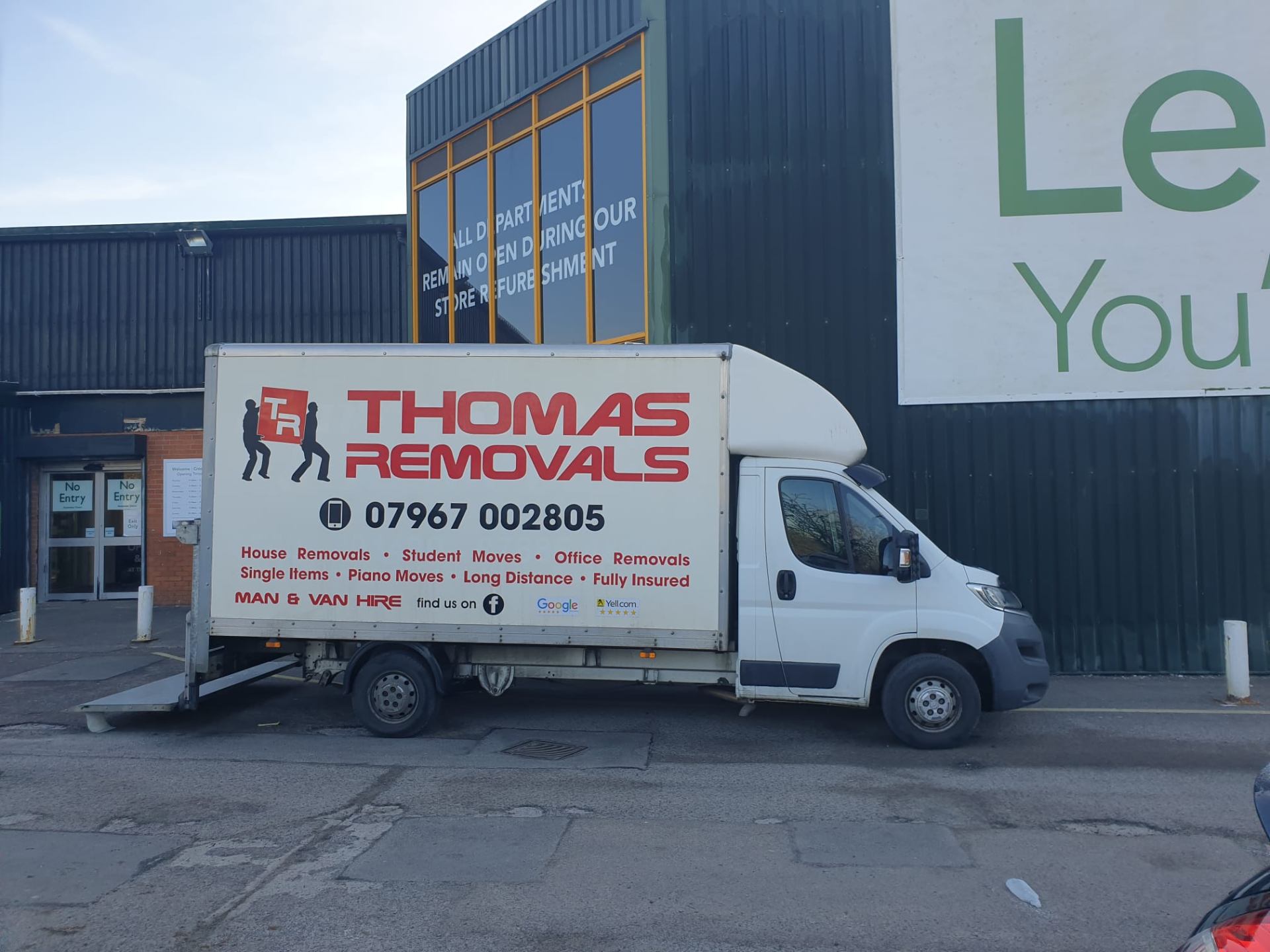 Thomas Removals van parked on a high street showing branded livery