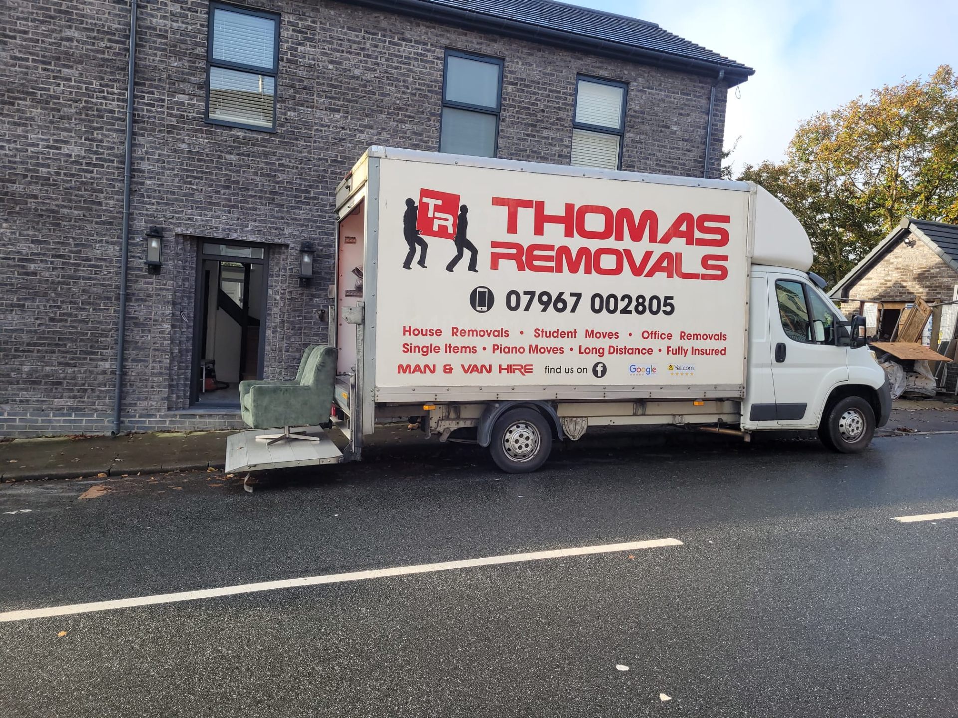 Thomas Removals van unloading furniture at a modern property